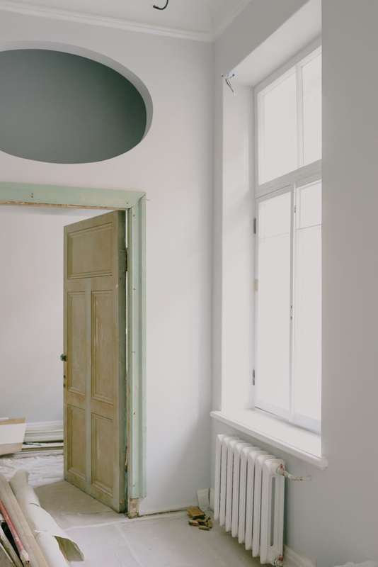 Bright apartment room being renovated beside a large window
