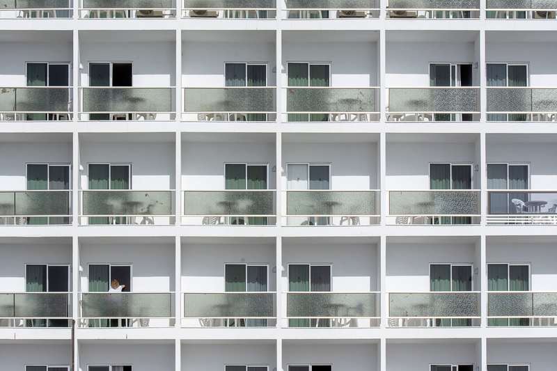 Apartment façade with repeated balconies and sliding glass doors