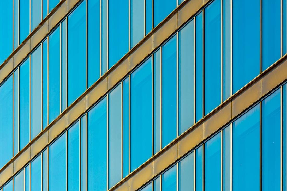Office façade with blue glass and warm metallic frames
