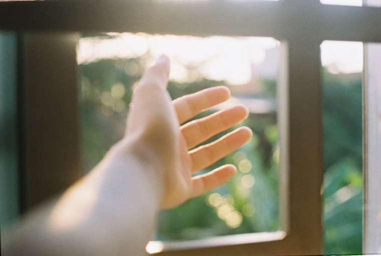 Hand operating an open casement window from inside