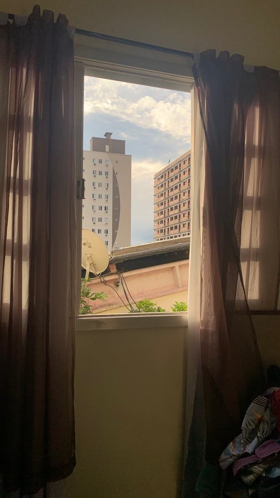 Open residential window looking toward city apartment buildings