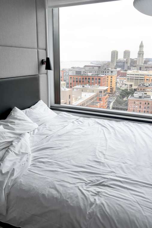 Hotel bedroom with a wide window and downtown view