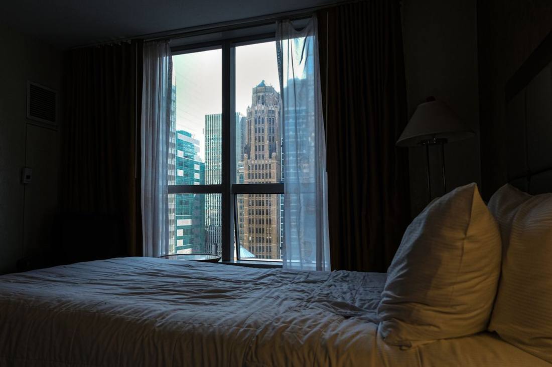 Modern hotel room beside a large urban window