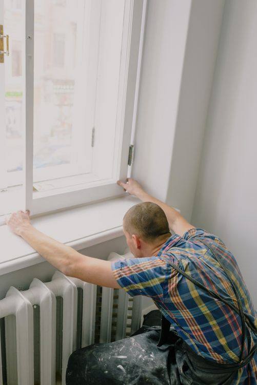 Installer mounting a window inside a residential room