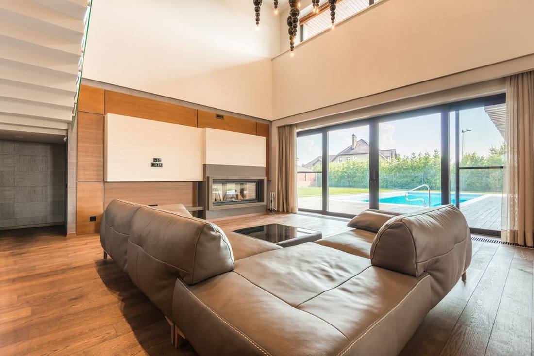 Living room with heavy glazed sliding doors overlooking a swimming pool