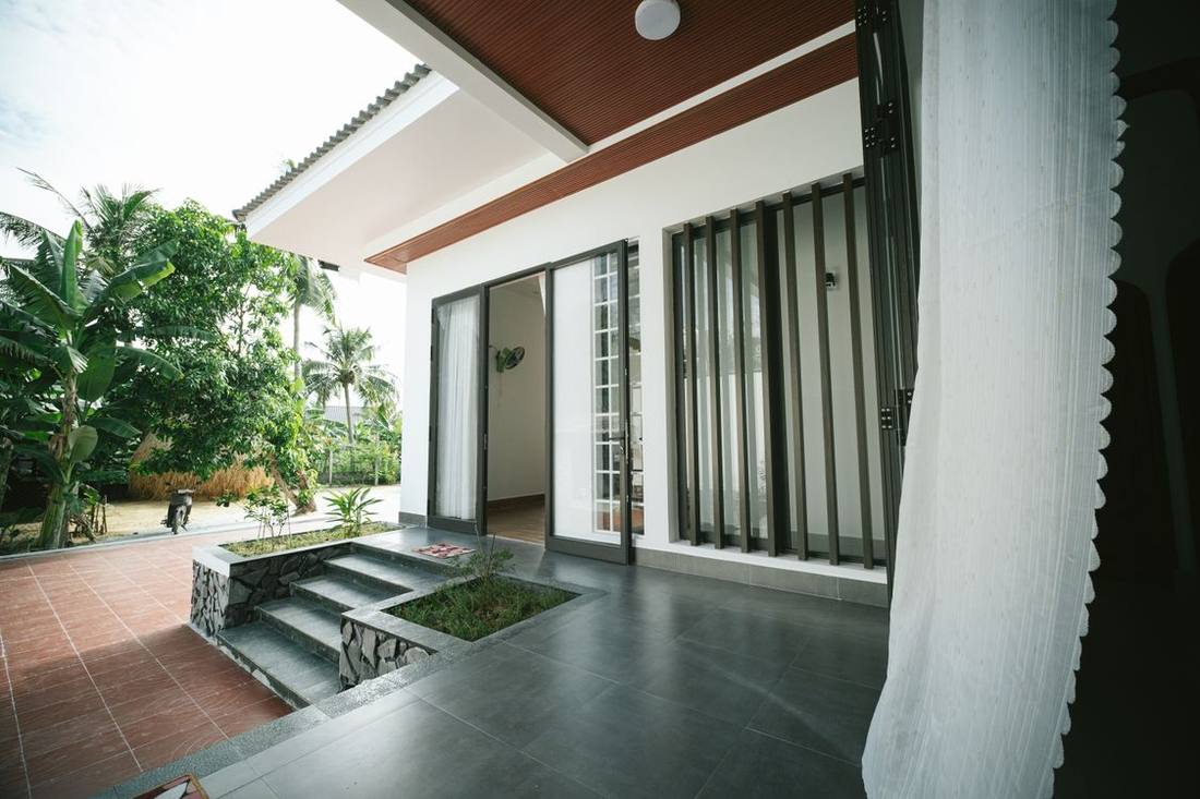 Modern house patio with broad glazed doors and garden