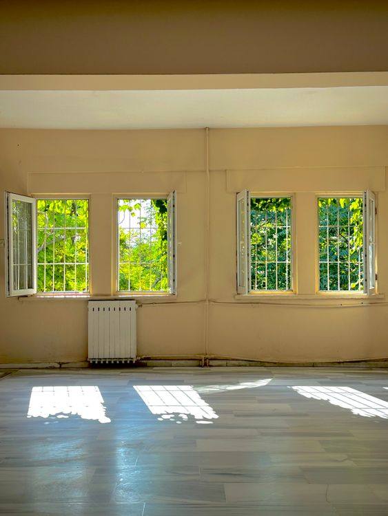 Bright room with open windows and sharp sunlight shadows