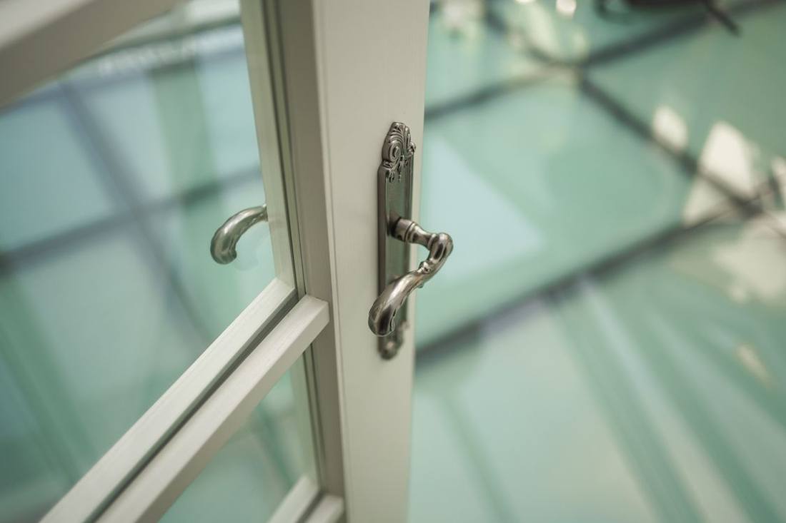 Close-up of a metal lever handle on a glazed door