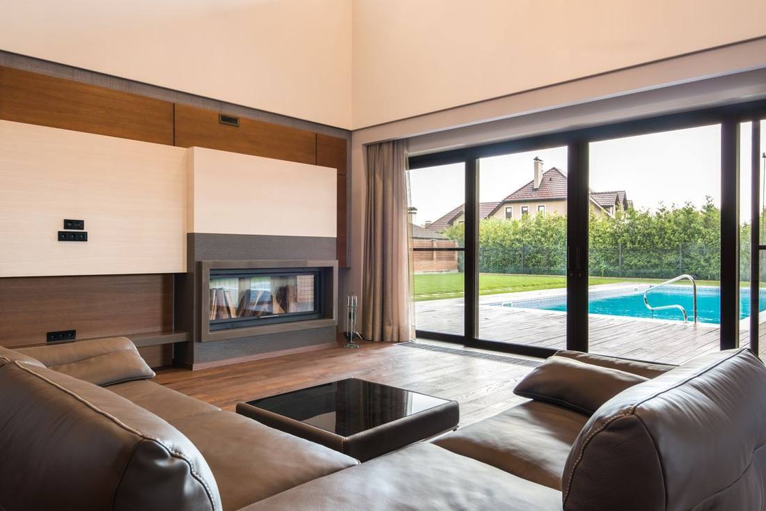 Living room with large glazed doors opening toward a pool
