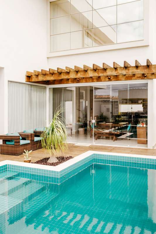 Modern patio with large glazed doors beside a swimming pool