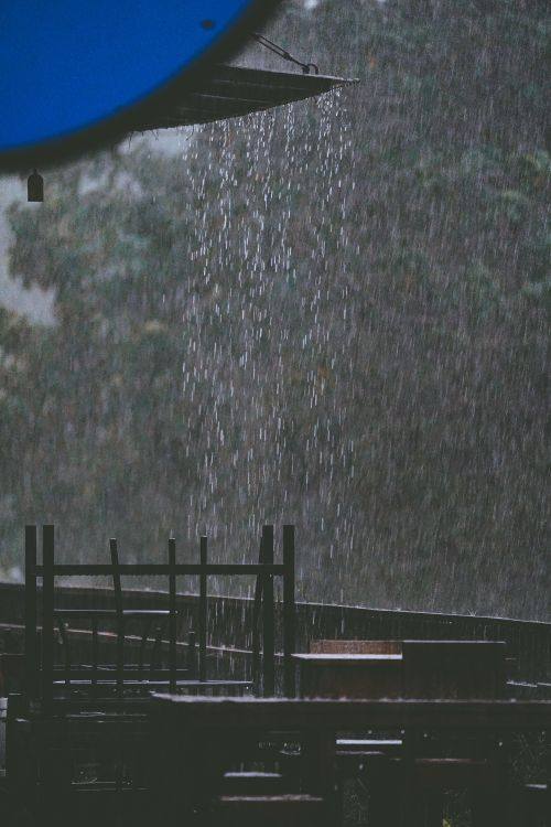 Intense rain falling from a roof onto an exposed terrace