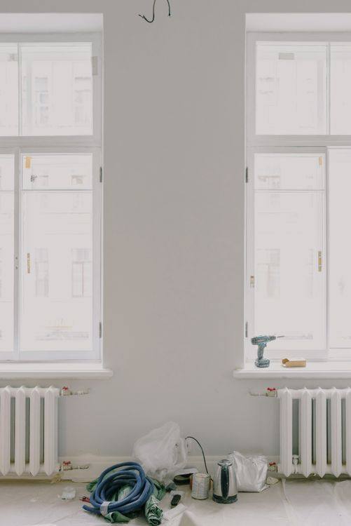 Bright apartment room with windows and renovation tools