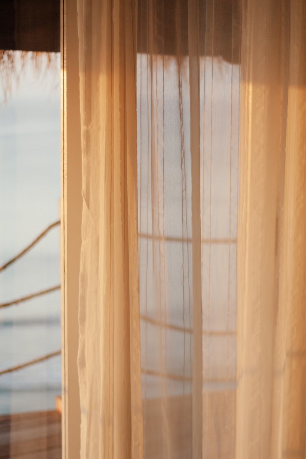 Sheer white curtain diffusing daylight at a window
