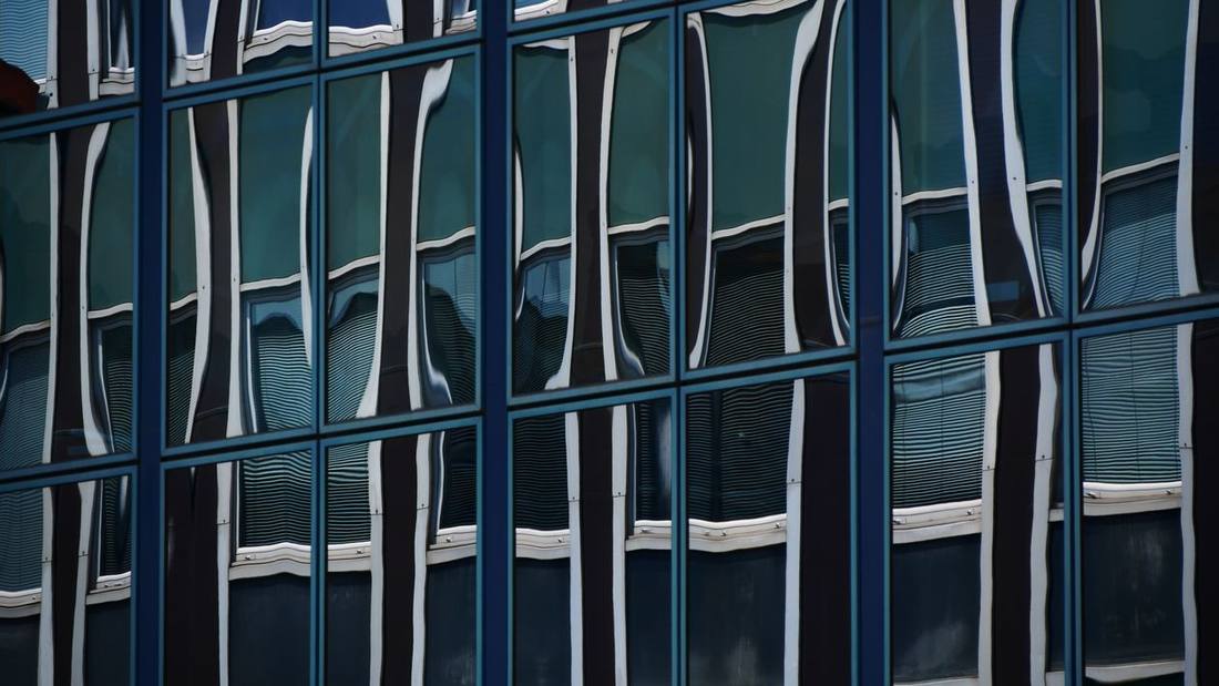 Abstract distorted reflections across modern skyscraper windows