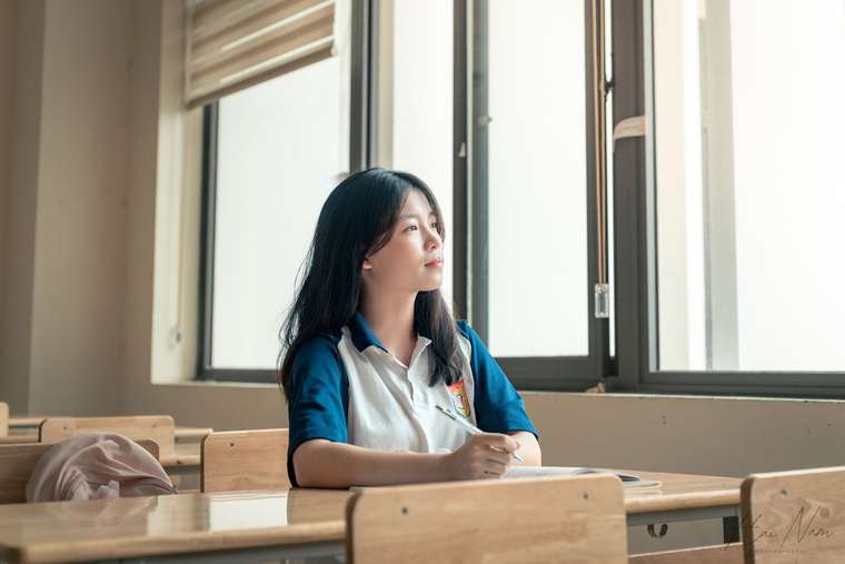 Student seated near a classroom window