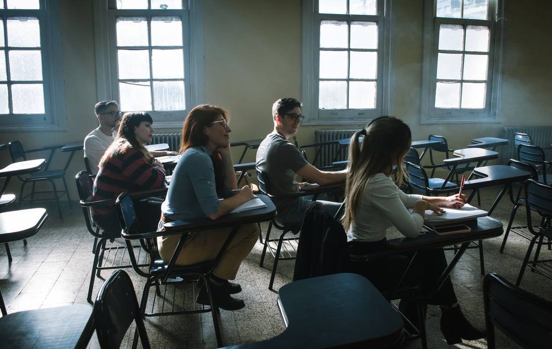 Students attending a lesson in daylight near windows