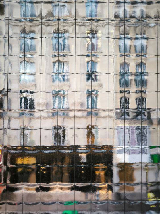 Building reflection visibly distorted through textured glazing