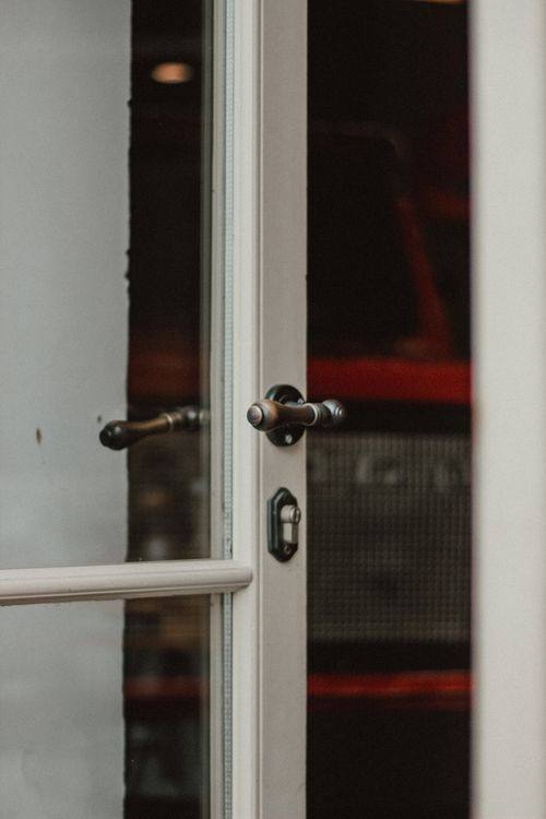 Close-up of a metal handle on a white-framed glazed door