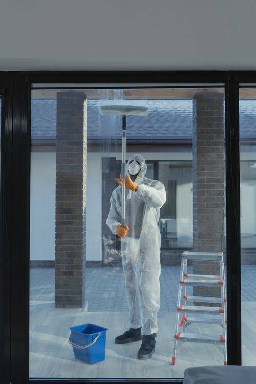 Professional cleaner working on a large glass window