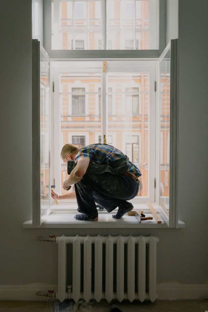 Technician working beside an open window frame