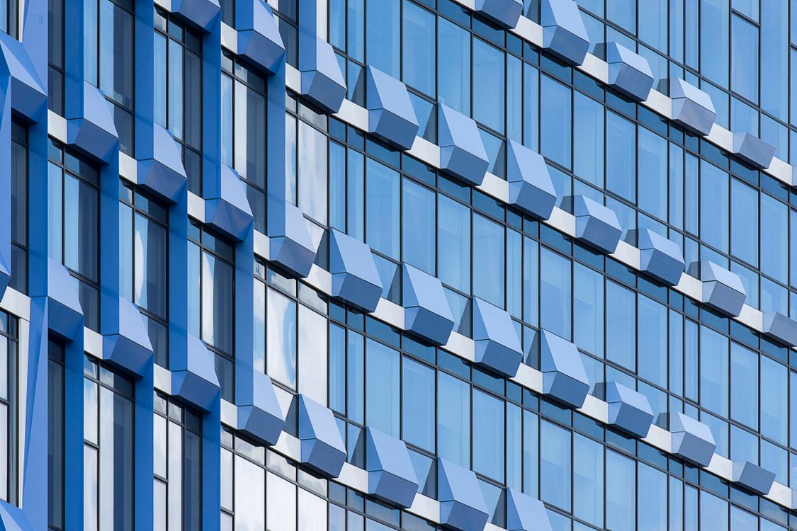 Blue geometric glass curtain wall panels viewed close up