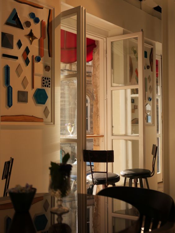 Open glass doors in a café interior with nearby furniture