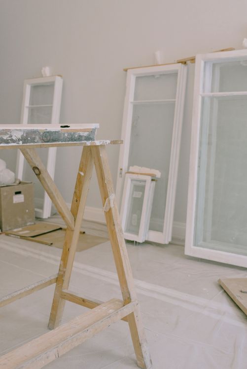 White window frames resting beside a workbench during renovation