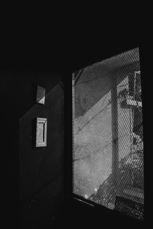 Monochrome view of a dark door and an adjacent light opening