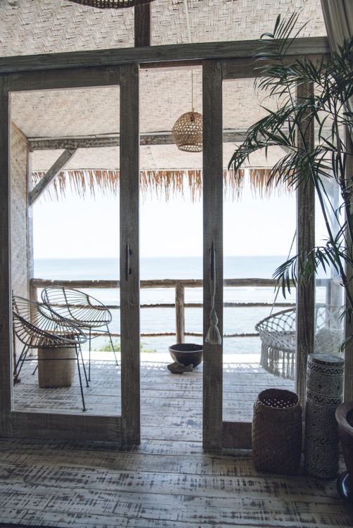 Open sliding doors leading to a wooden seaside balcony