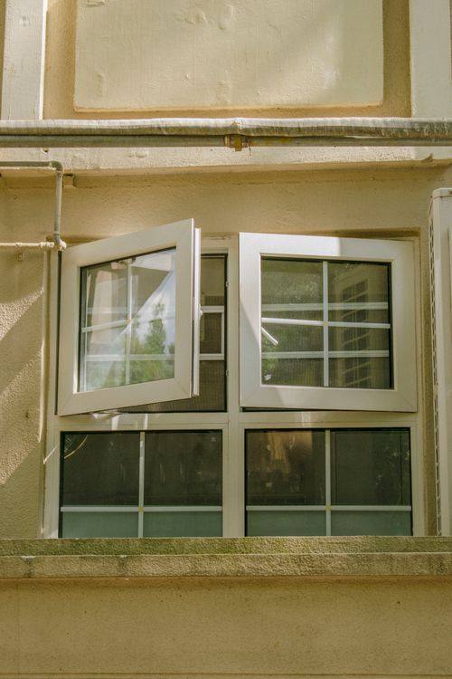 Building façade with several operable windows in sunlight