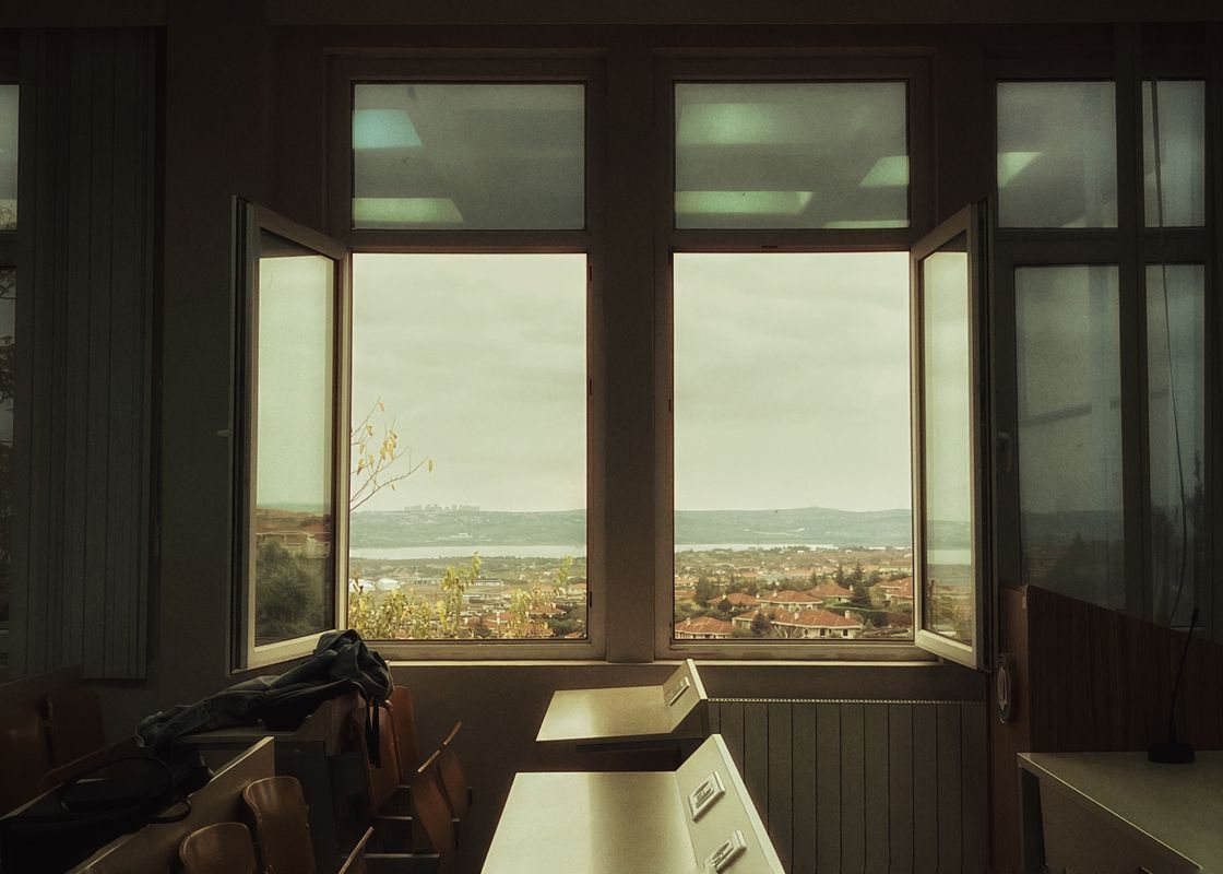 Open classroom windows over a town