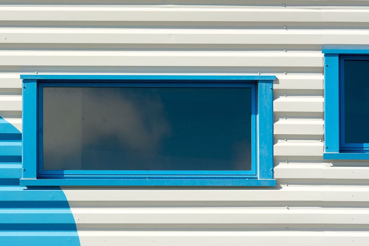 Blue-framed windows on a light-coloured facade