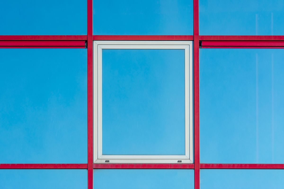 Modern facade with red frames and blue glass