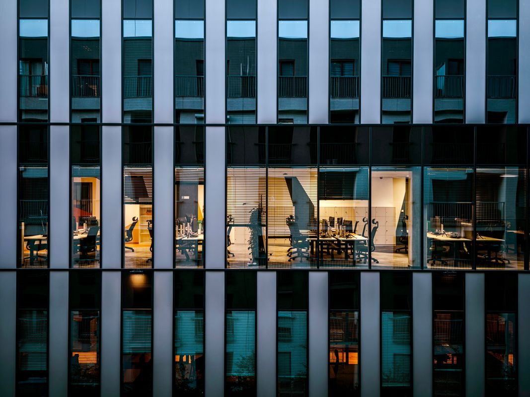 Lit offices visible through a glazed building facade