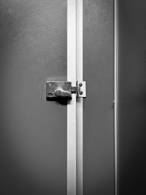 Close view of a metal door lock and operating hardware