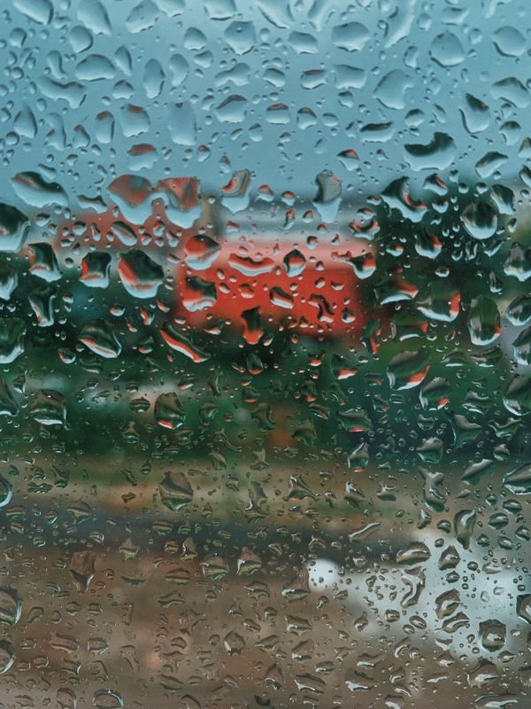 Raindrops on a window with a blurred outdoor view
