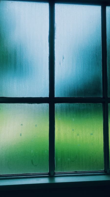 Dew and mist across a window with a blurred outdoor view