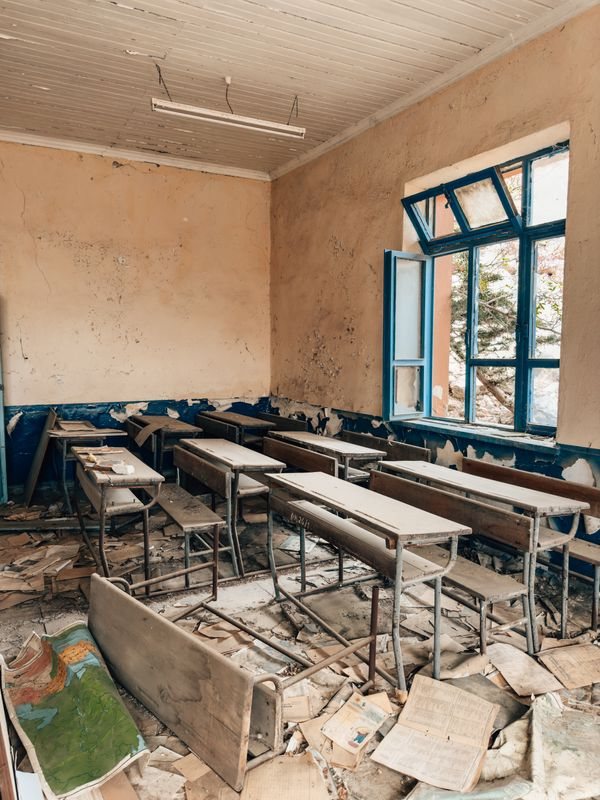 Unused classroom with windows and damaged furnishings