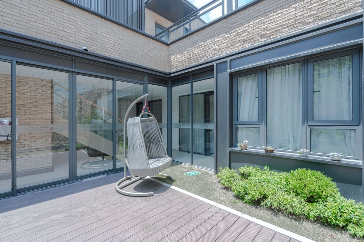 Modern villa patio beside broad glazed walls