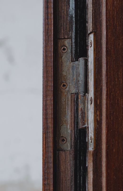 Weathered hinge and fasteners on a timber door