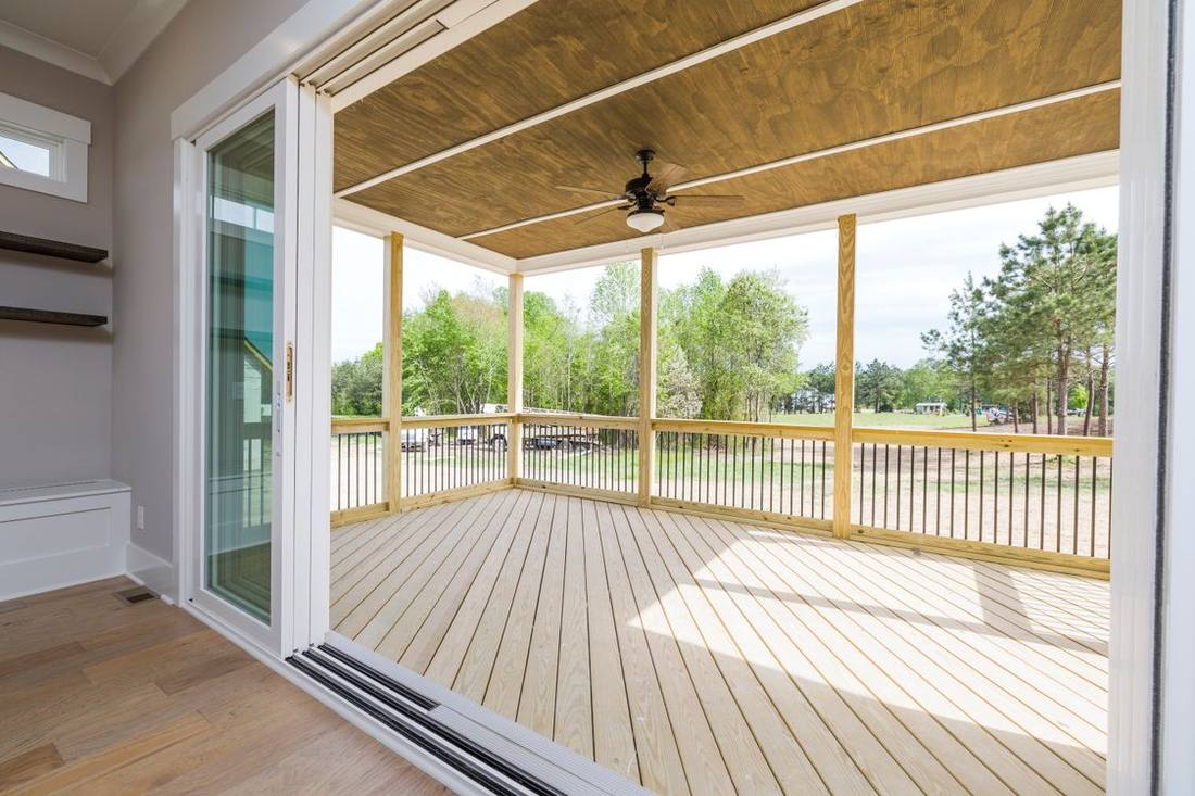 Wide residential veranda opening with wooden floor and glazed doors