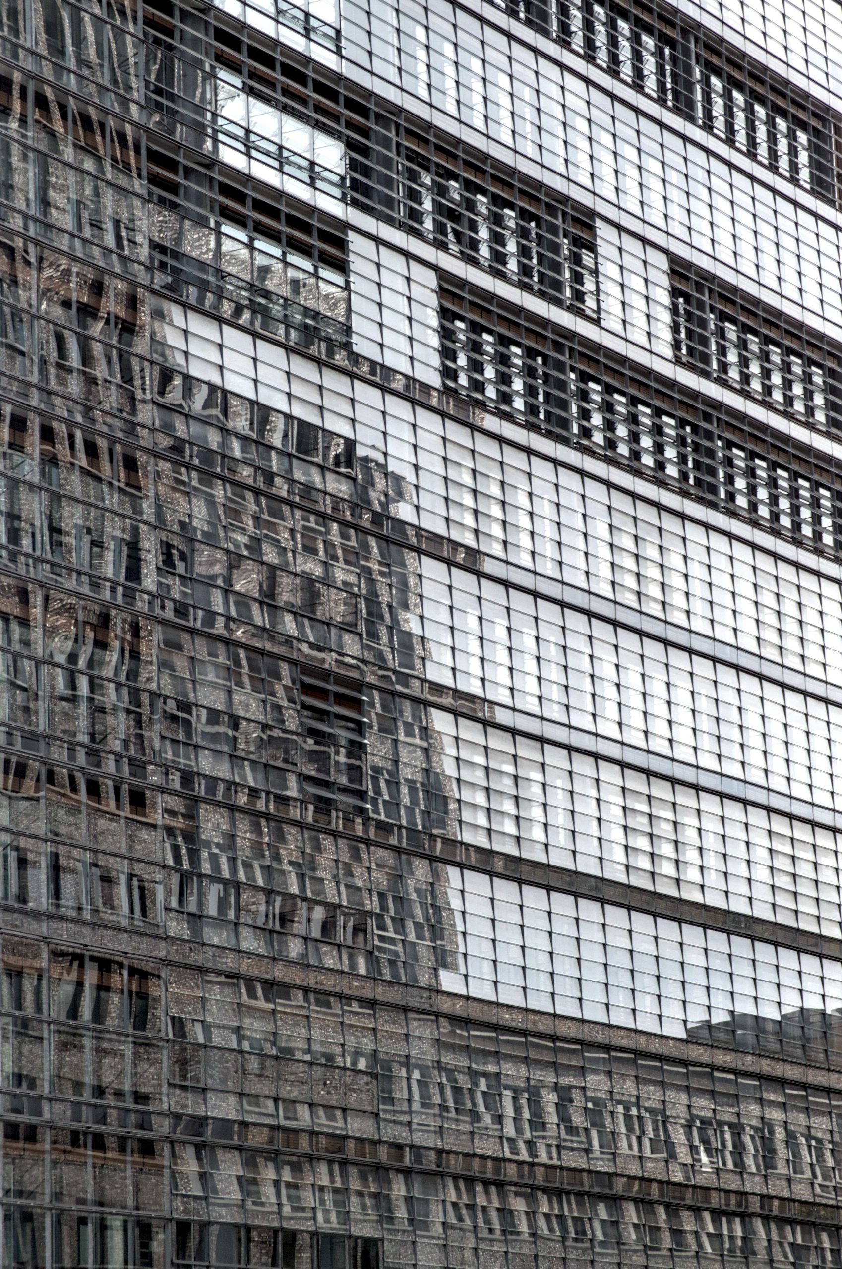 Repeated glass facade bays reflecting neighbouring buildings.